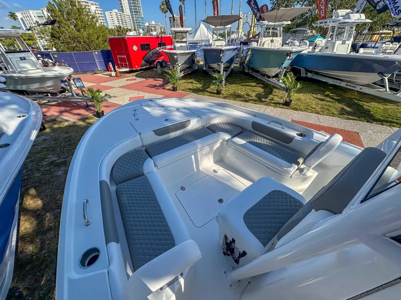 Slide: The Image of 2025 Caymas 24 HB boat with spacious seating, displayed outdoors at a boat show. - 20