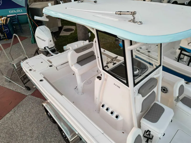Slide: The Image of 2025 Caymas 24 HB boat with center console and seating, displayed outdoors. - 4