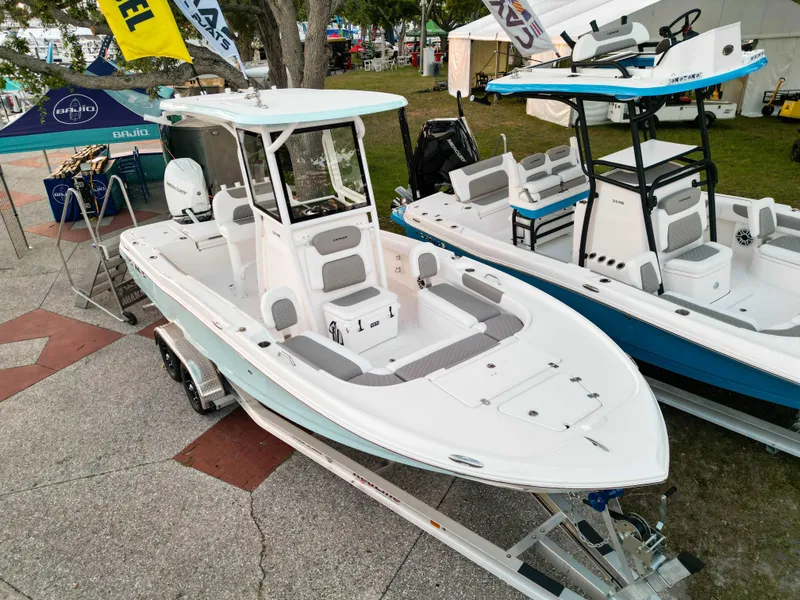 Slide: The Image of 2025 Caymas 24 HB boat displayed on a trailer at an outdoor event. - 5