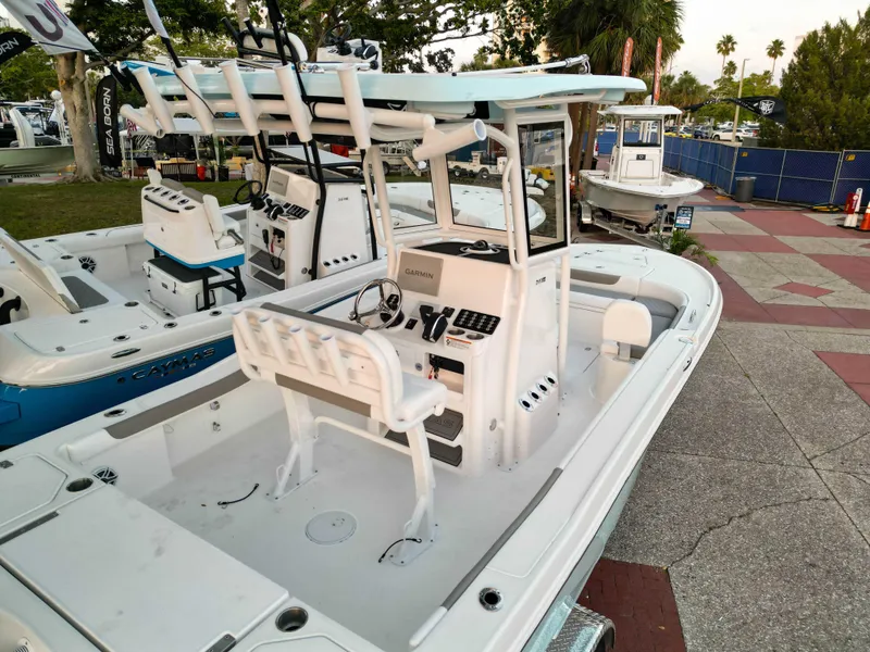 Slide: The Image of 2025 Caymas 24 HB boat with center console and seating, displayed outdoors. - 6