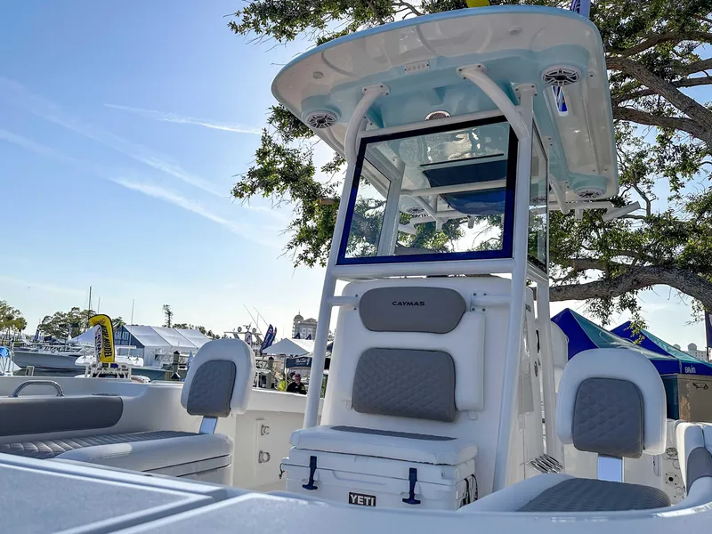 Slide: The Image of 2025 Caymas 24 HB boat interior with seating and canopy, displayed outdoors. - 8
