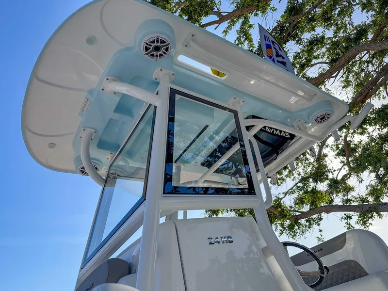 Slide: The Image of 2025 Caymas 24 HB boat with T-top and speakers, viewed from below against a tree backdrop. - 9
