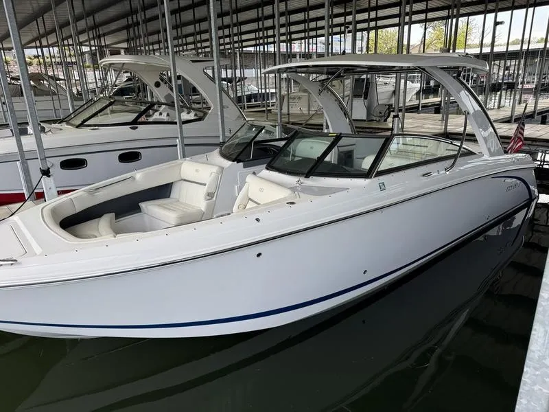 Slide: The Image of 2018 Cobalt R30 boat docked in a marina, featuring sleek white design and spacious seating. - 1
