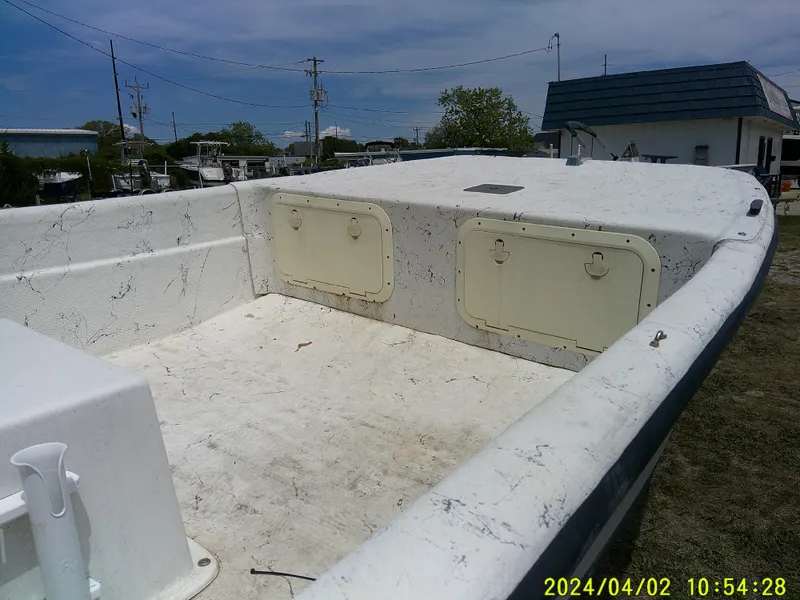 Slide: The Image of 2000 Carolina Skiff 1765 DLX boat interior with storage compartments, photographed outdoors. - 10