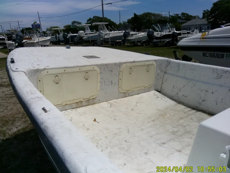 Slide: The Image of 2000 Carolina Skiff 1765 DLX boat interior, white deck, storage compartments, outdoor display. - 12