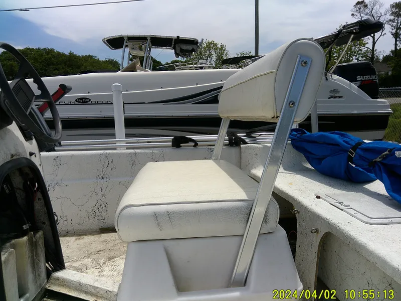 Slide: The Image of 2000 Carolina Skiff 1765 DLX boat interior with white seating and blue life jacket. - 14