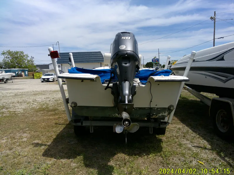 Slide: The Image of 2000 Carolina Skiff 1765 DLX boat with outboard motor, parked on grass. - 4