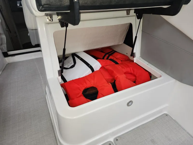 Slide: The Image of Storage compartment with life jackets on a 2023 Regal 28 Express boat. - 10