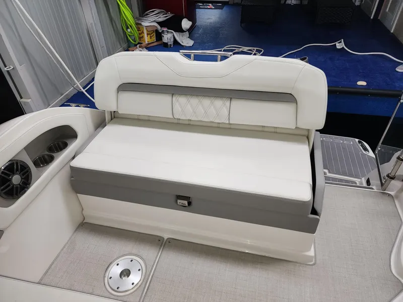 Slide: The Image of 2023 Regal 28 Express boat interior with white cushioned seating and cup holders. - 11