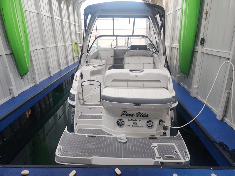Slide: The Image of 2023 Regal 28 Express boat docked indoors, featuring sleek design and spacious seating. - 2