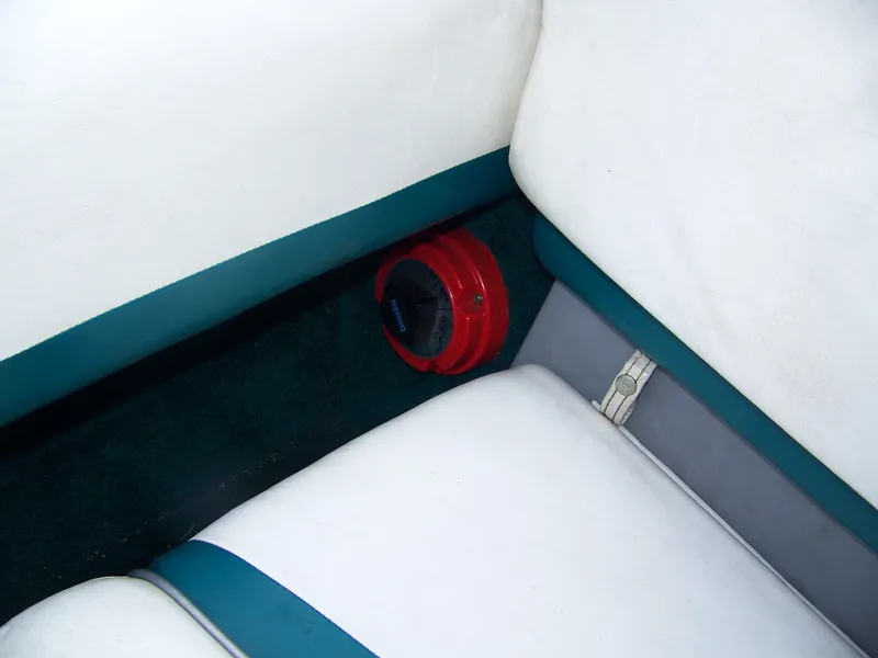 Slide: The Image of 2000 Glastron SX195 boat interior with white and teal seating, featuring a red speaker. - 10