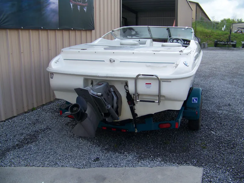 Slide: The Image of 2000 Glastron SX195 boat on trailer, rear view, parked on gravel. - 3