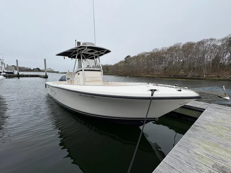 Slide: The Image of 2008 Pursuit 2570 CC boat docked in a calm marina setting. - 1