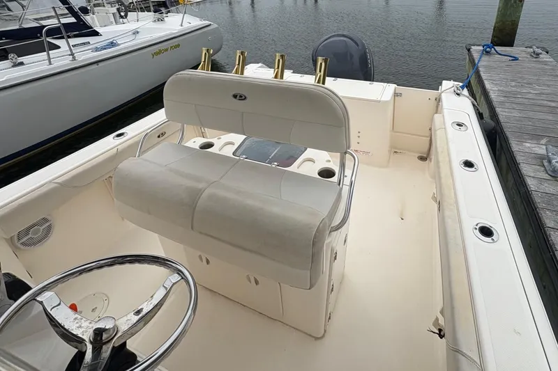 Slide: The Image of 2008 Pursuit 2570 CC boat interior with seating and steering wheel at dock. - 11