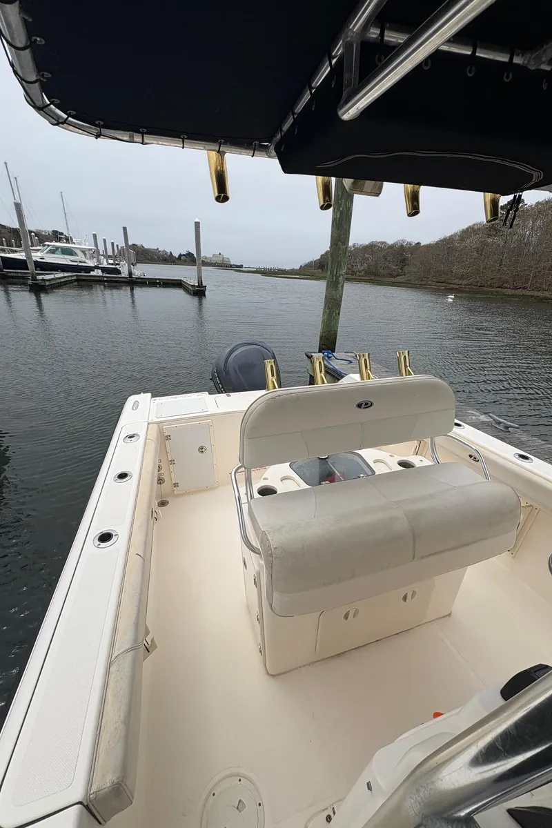 Slide: The Image of 2008 Pursuit 2570 CC boat docked, featuring spacious deck and seating. - 12