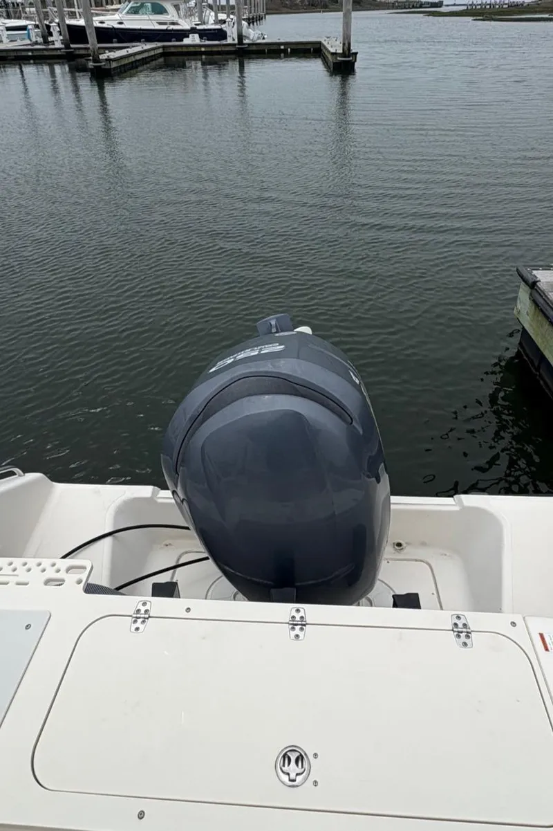 Slide: The Image of 2008 Pursuit 2570 CC boat with outboard motor at a marina dock. - 13