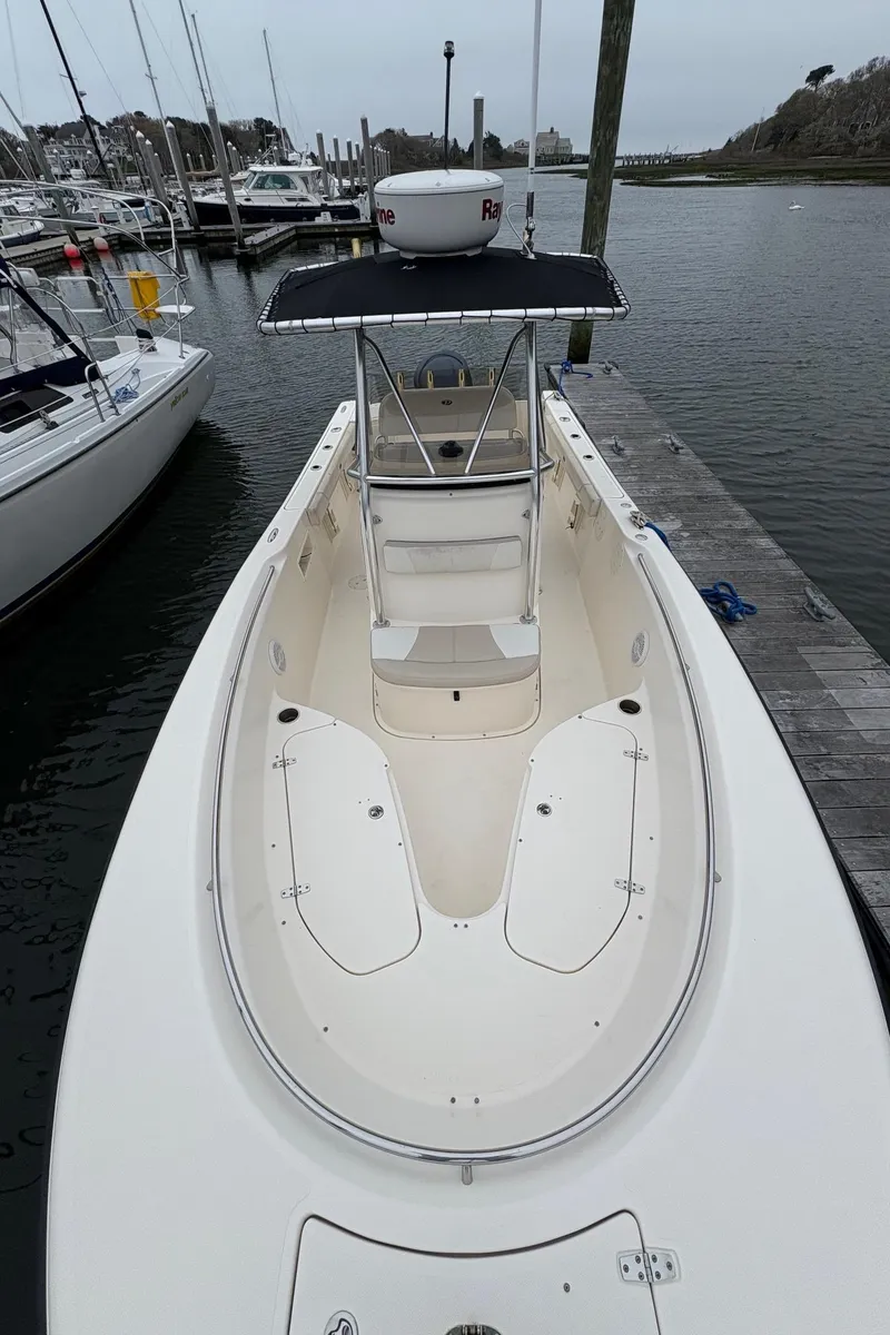 Slide: The Image of 2008 Pursuit 2570 CC boat docked at marina, featuring spacious deck and T-top. - 18
