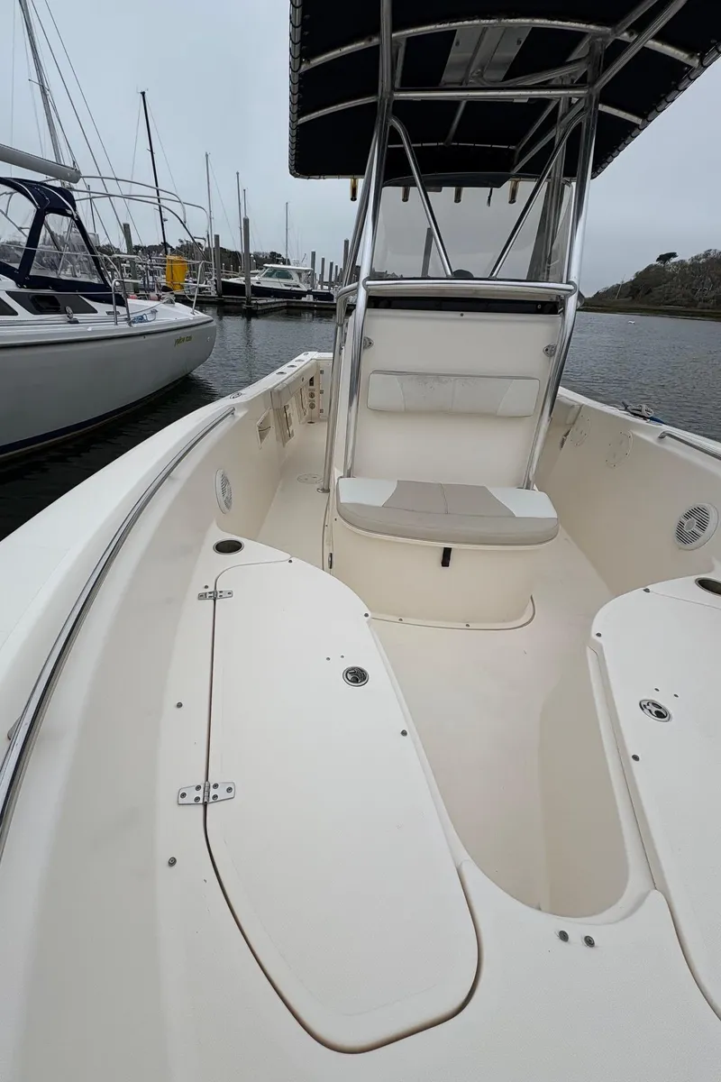 Slide: The Image of 2008 Pursuit 2570 CC boat with seating, docked in a marina. - 20