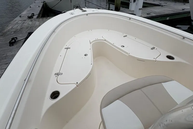 Slide: The Image of 2008 Pursuit 2570 CC boat interior with seating and storage compartments at a dock. - 21