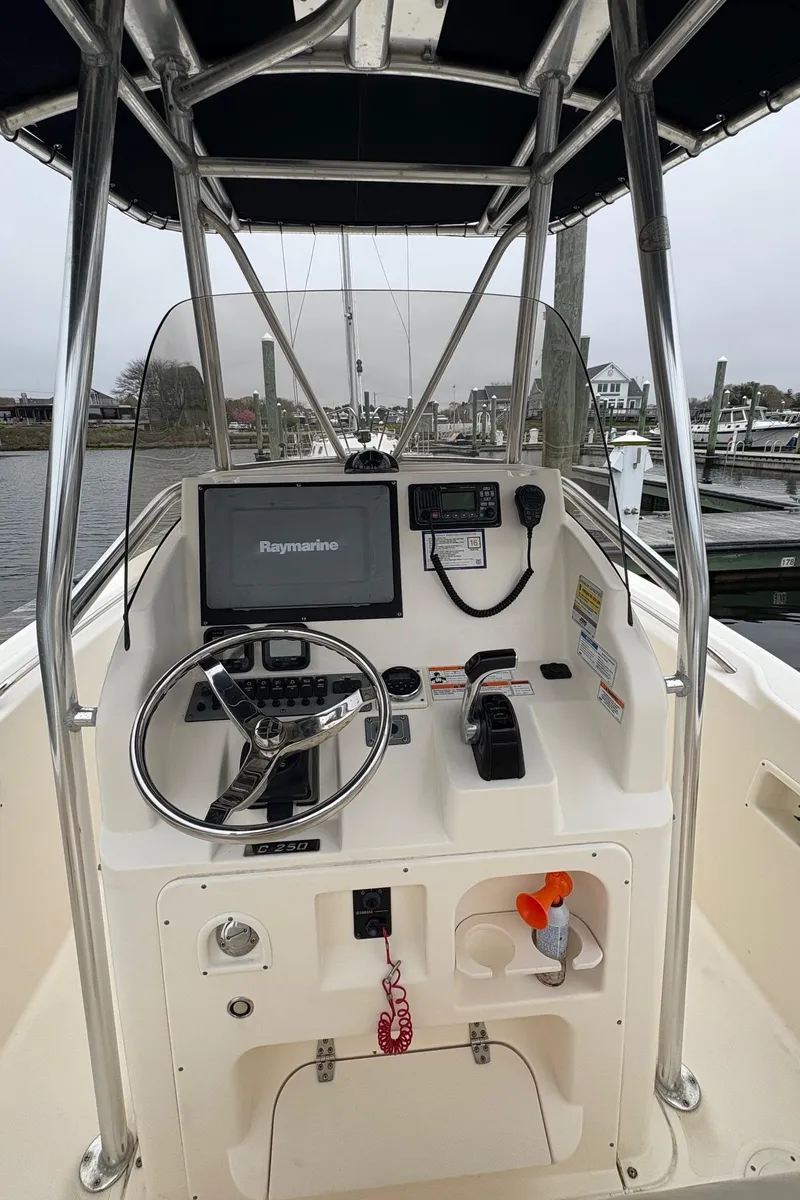 Slide: The Image of 2008 Pursuit 2570 CC boat console with steering wheel, navigation equipment, and storage compartments. - 7