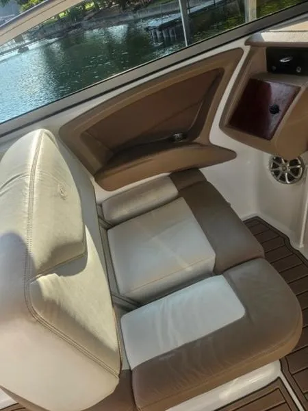Slide: The Image of 2010 Cobalt 302 boat interior with beige and white seating, near water. - 10