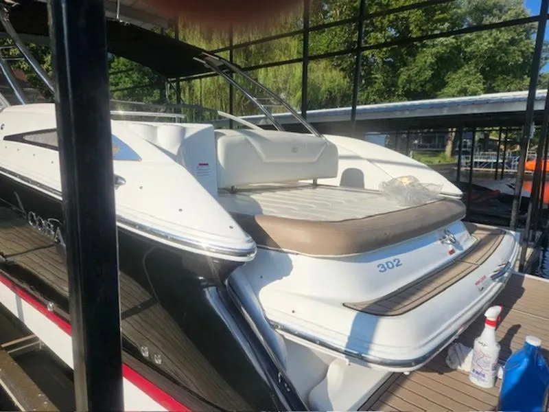 Slide: The Image of 2010 Cobalt 302 boat docked, featuring sleek design and spacious deck area. - 12