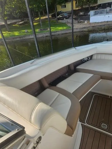Slide: The Image of 2010 Cobalt 302 boat interior with beige seating near a calm waterfront. - 15