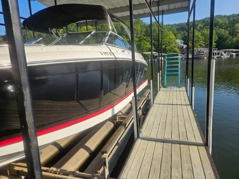 Slide: The Image of 2010 Cobalt 302 boat docked under a covered pier on a sunny day. - 17