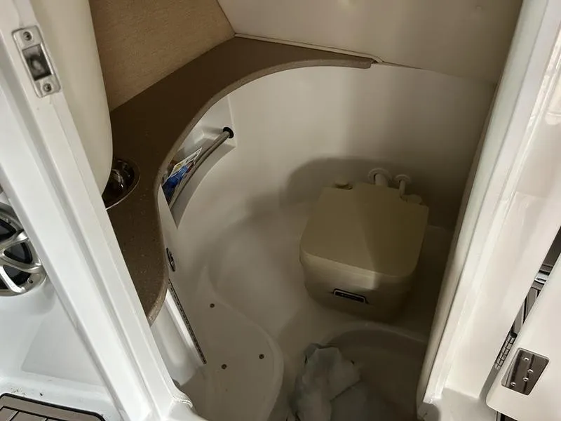 Slide: The Image of 2010 Cobalt 302 boat interior with compact bathroom and portable toilet. - 26