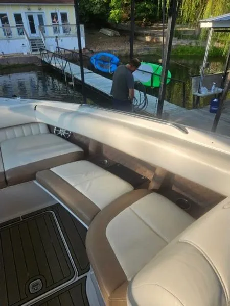 Slide: The Image of 2010 Cobalt 302 boat with beige seating, docked near a waterfront house. - 3