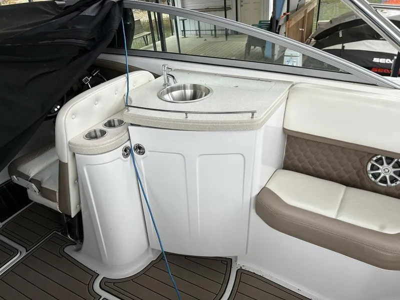 Slide: The Image of 2010 Cobalt 302 boat interior with sink, cup holders, and cushioned seating. - 30