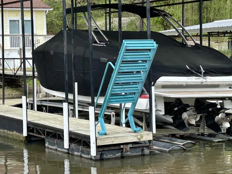Slide: The Image of Covered 2010 Cobalt 302 boat docked with stacked turquoise chairs nearby. - 32