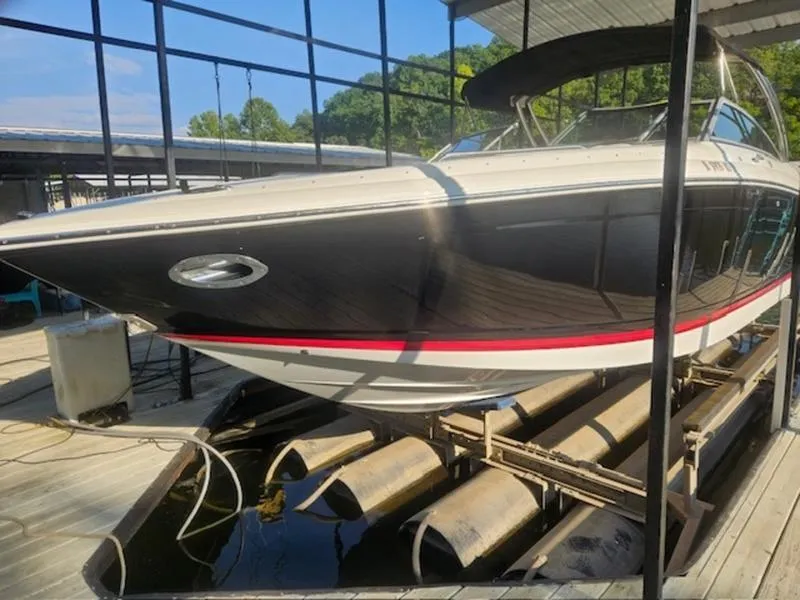 Slide: The Image of 2010 Cobalt 302 boat docked, featuring sleek black and white design with red accent stripe. - 7
