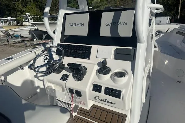 Slide: The Image of 2025 Tidewater 272 CC Adventure boat console with dual Garmin displays and steering wheel. - 6
