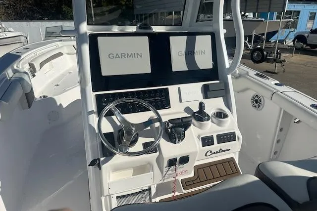 Slide: The Image of 2025 Tidewater 272 CC Adventure boat dashboard with dual Garmin displays and steering wheel. - 7