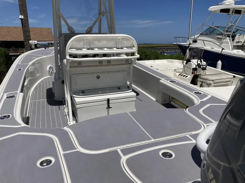 Slide: The Image of 2016 SeaVee 270Z boat with spacious deck and seating, docked under clear blue skies. - 17