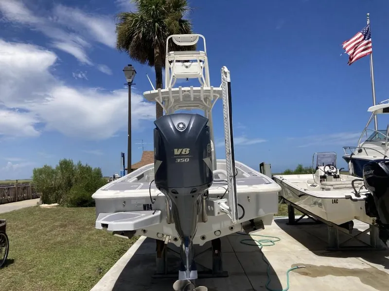 Slide: The Image of 2016 SeaVee 270Z boat with V8 engine, docked near American flag and palm tree. - 2