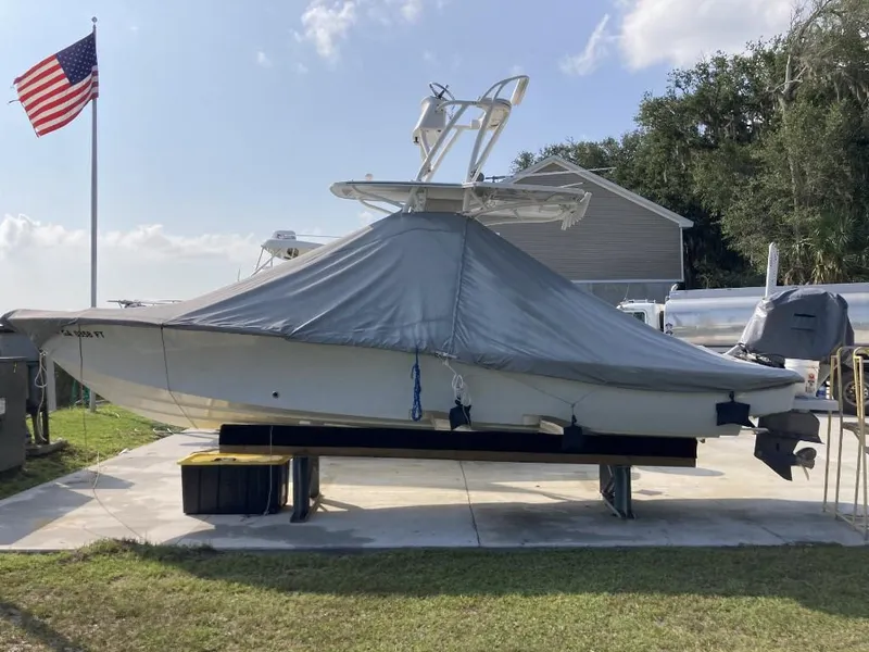 Slide: The Image of 2016 SeaVee 270Z boat covered, on a lift, with American flag in background. - 3