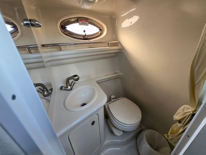 Slide: The Image of 2007 Sea Ray 260 Sundancer bathroom with sink, toilet, and porthole window. - 14