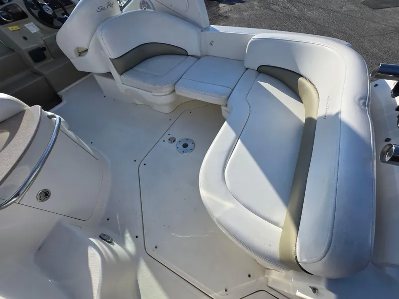 Slide: The Image of 2007 Sea Ray 260 Sundancer boat interior with white cushioned seating. - 16