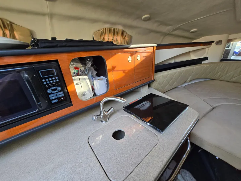 Slide: The Image of 2007 Sea Ray 260 Sundancer cabin with kitchenette, sink, and seating area. - 17