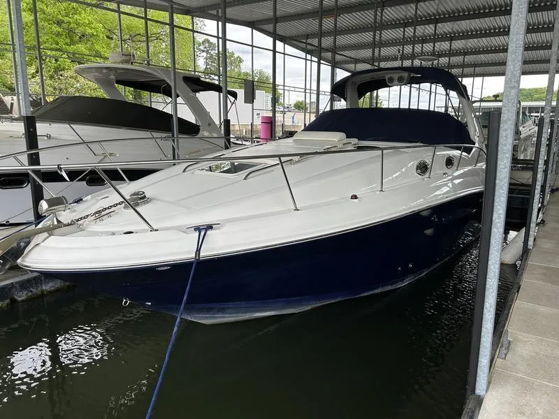 Slide: The Image of 2005 Sea Ray 320 Sun Dancer docked in a marina under a covered shelter. - 1