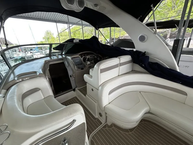 Slide: The Image of 2005 Sea Ray 320 Sun Dancer interior with helm, seating, and covered dashboard. - 13