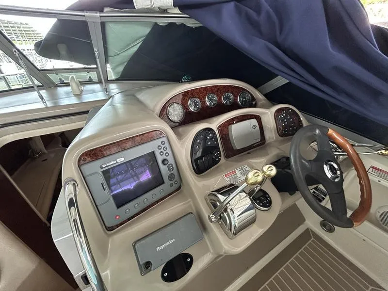 Slide: The Image of 2005 Sea Ray 320 Sun Dancer helm with navigation controls and steering wheel. - 19
