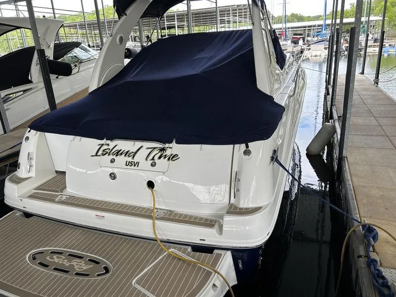 Slide: The Image of 2005 Sea Ray 320 Sun Dancer docked, covered, with "Island Time" on the stern. - 2