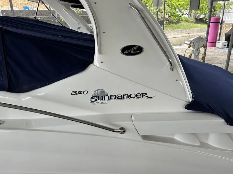 Slide: The Image of 2005 Sea Ray 320 Sun Dancer boat with navy cover, docked in a marina. - 4