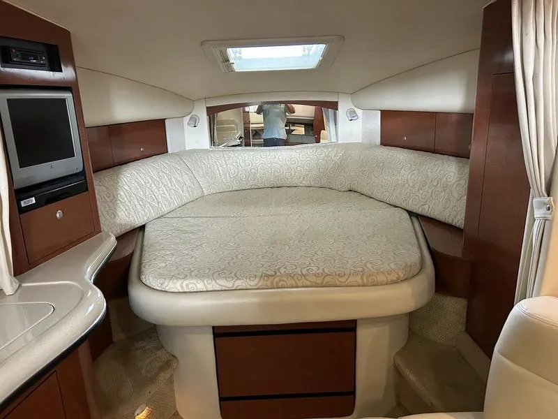 Slide: The Image of 2005 Sea Ray 320 Sun Dancer cabin interior with bed, TV, and wood accents. - 6