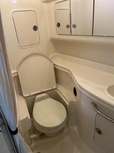 Slide: The Image of 2005 Sea Ray 320 Sun Dancer bathroom with toilet and storage cabinets. - 7