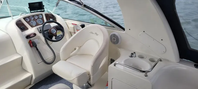 Slide: The Image of 2004 Sea Ray Sundancer 260 cockpit with steering wheel, control panel, and seating. - 10