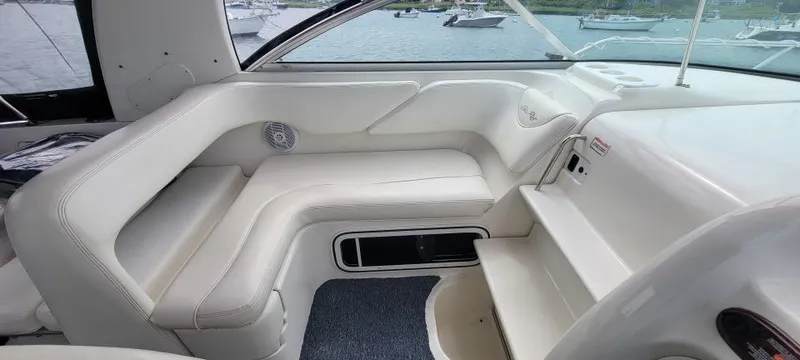 Slide: The Image of 2004 Sea Ray Sundancer 260 interior with white seating and waterfront view. - 18